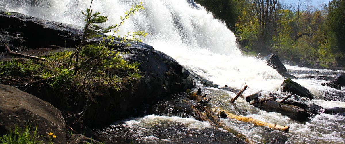 A waterfall cascading over rocks in a forested area.