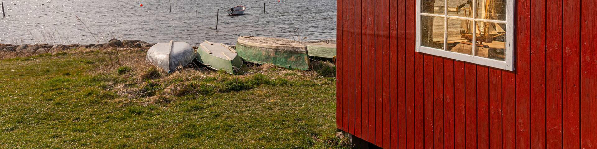 a red hut on the shore an some boats at Jyllinge, Denmark, Marts 29, 2022