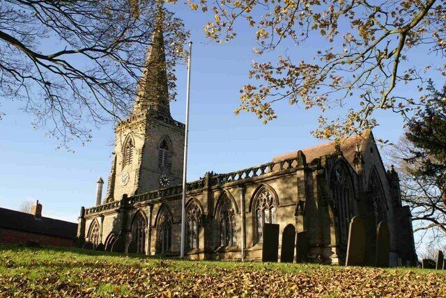 A historic church with a tall spire and arched windows.