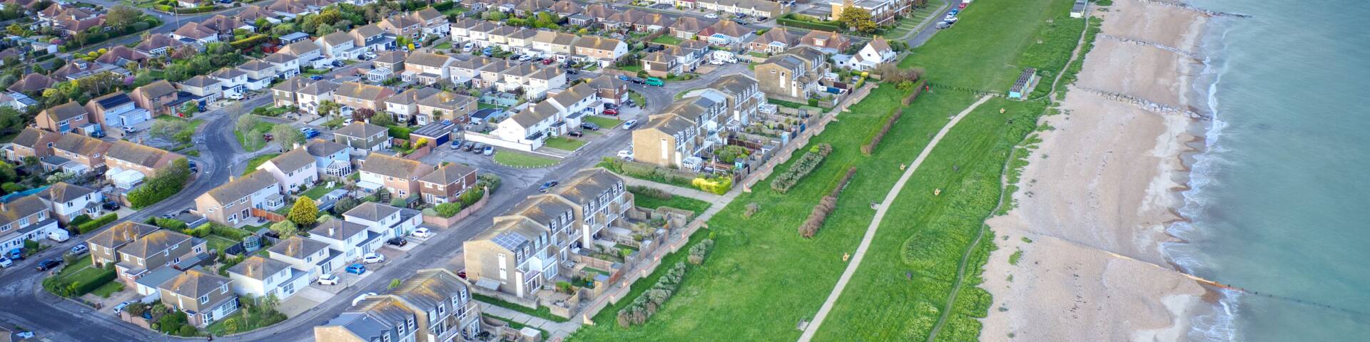 Aerial view of Rustington Village in West Sussex on the seafront by Broadmark Lane looking towards East Preston.