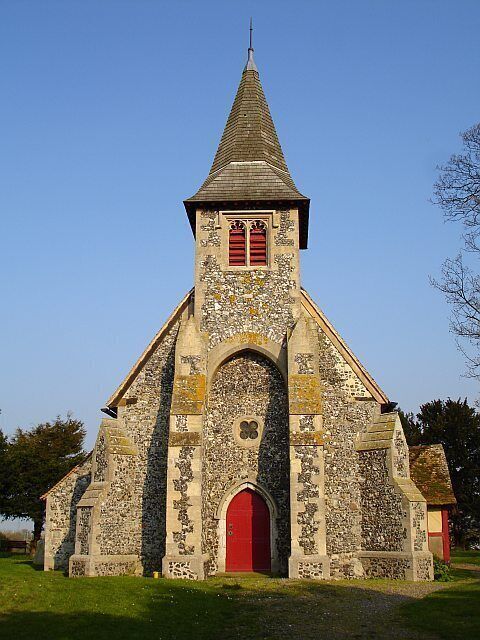 A stone church with a red door and a pointed steeple.