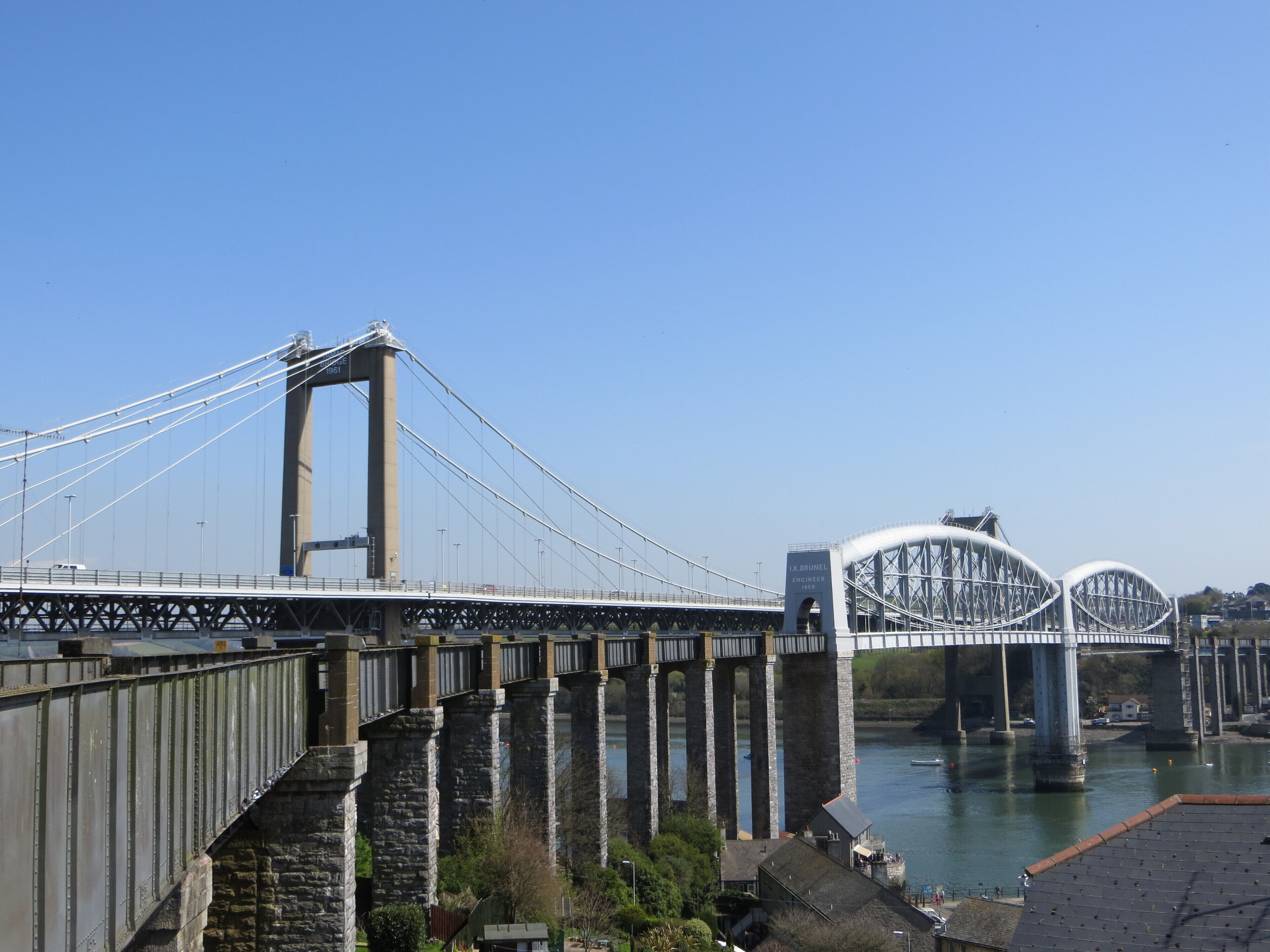 A large suspension bridge with stone pillars and a river below.