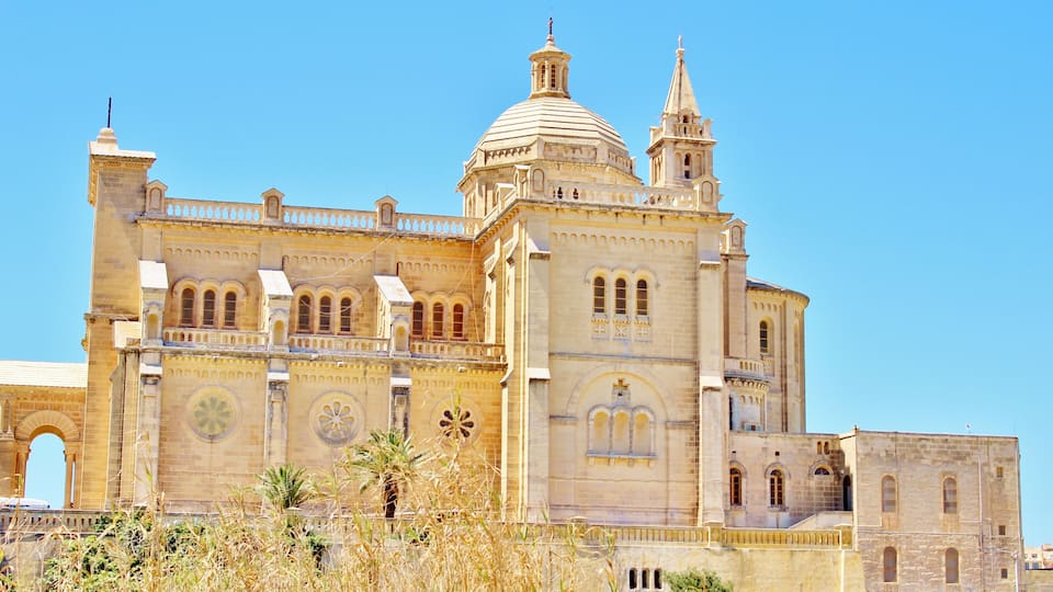 A large, historic building with a prominent dome and bell tower.