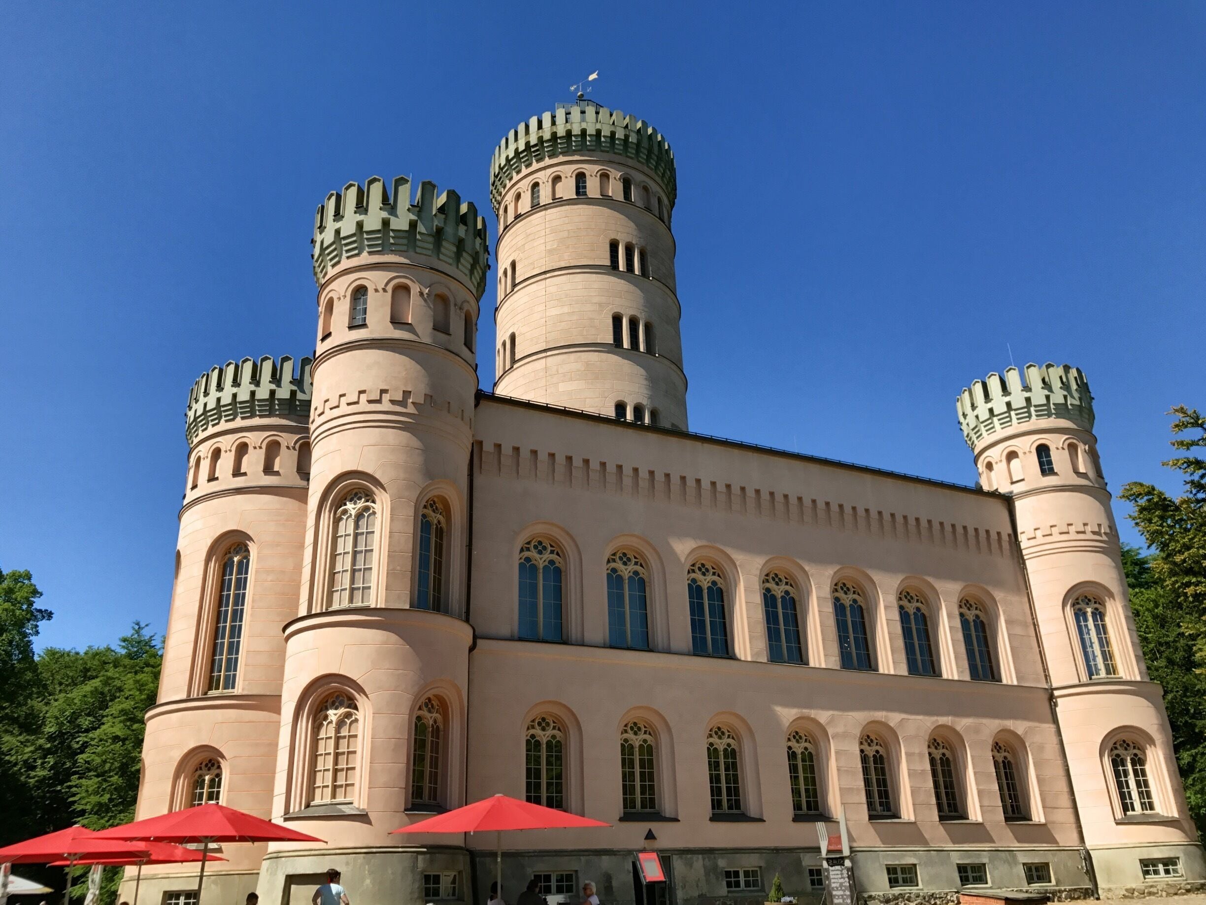 A castle with multiple towers and arched windows.