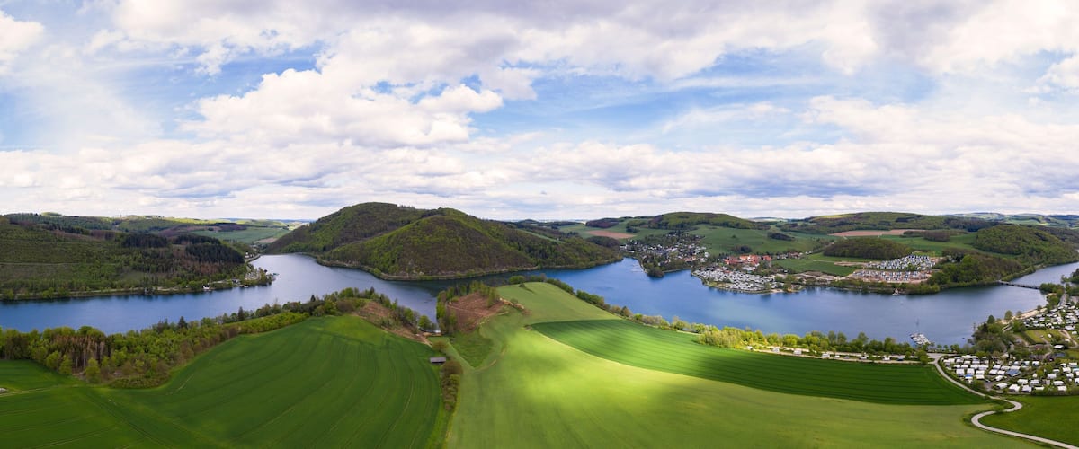 A lake surrounded by green fields and hills.