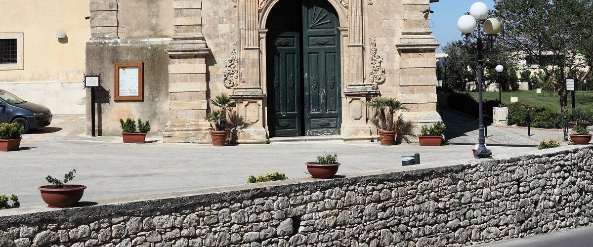 A historic church with a bell tower, a green door, and stone walls.