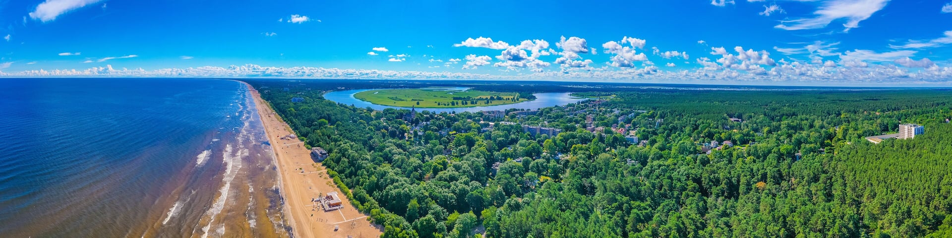 A coastal city with a beach, a river, and a forested area.