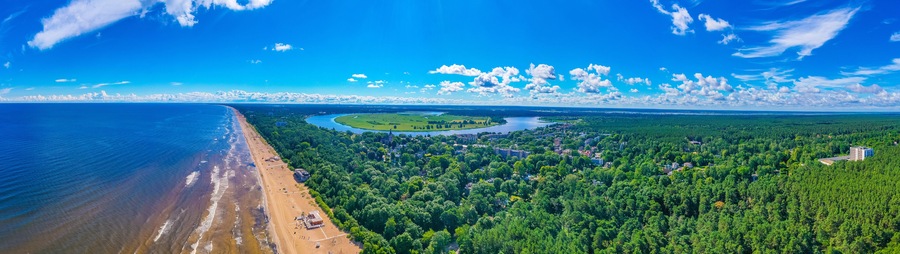 Rannikkokaupunki, jossa on ranta, joki ja metsäinen alue.
