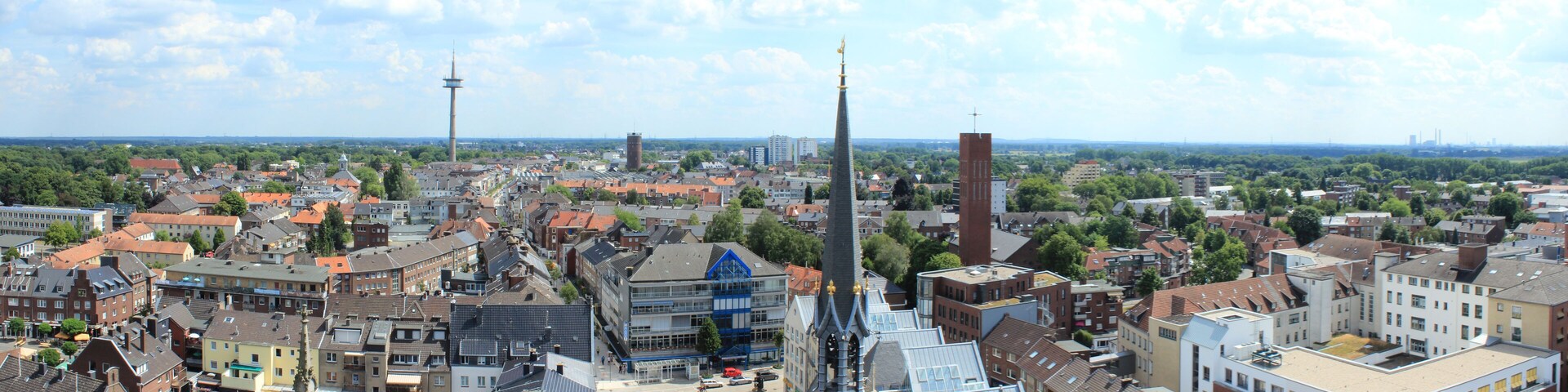 A cityscape with a prominent tower, a large open square, and surrounding residential buildings.