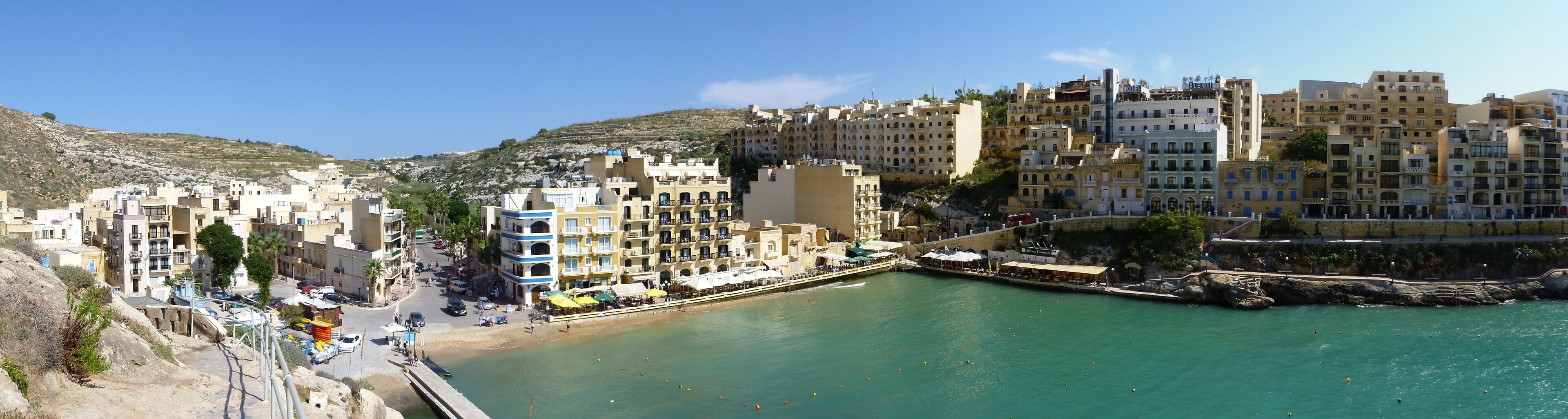 Panorama of the inner part of Xlendi bay with the beach and many restaurants at the shore line