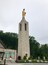A tall stone tower with a statue at the top.