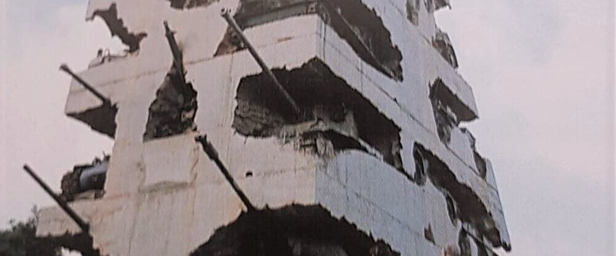 A damaged building with exposed beams and a collapsed roof.