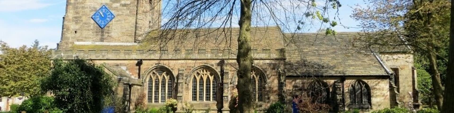 A historic stone church with a clock tower and arched windows.