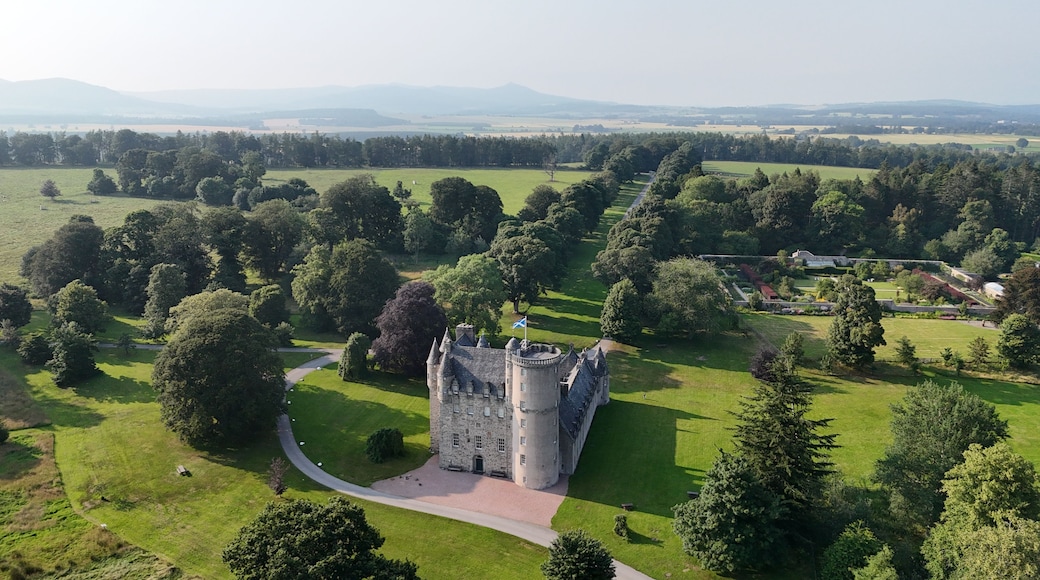 A castle surrounded by lush greenery and rolling hills.