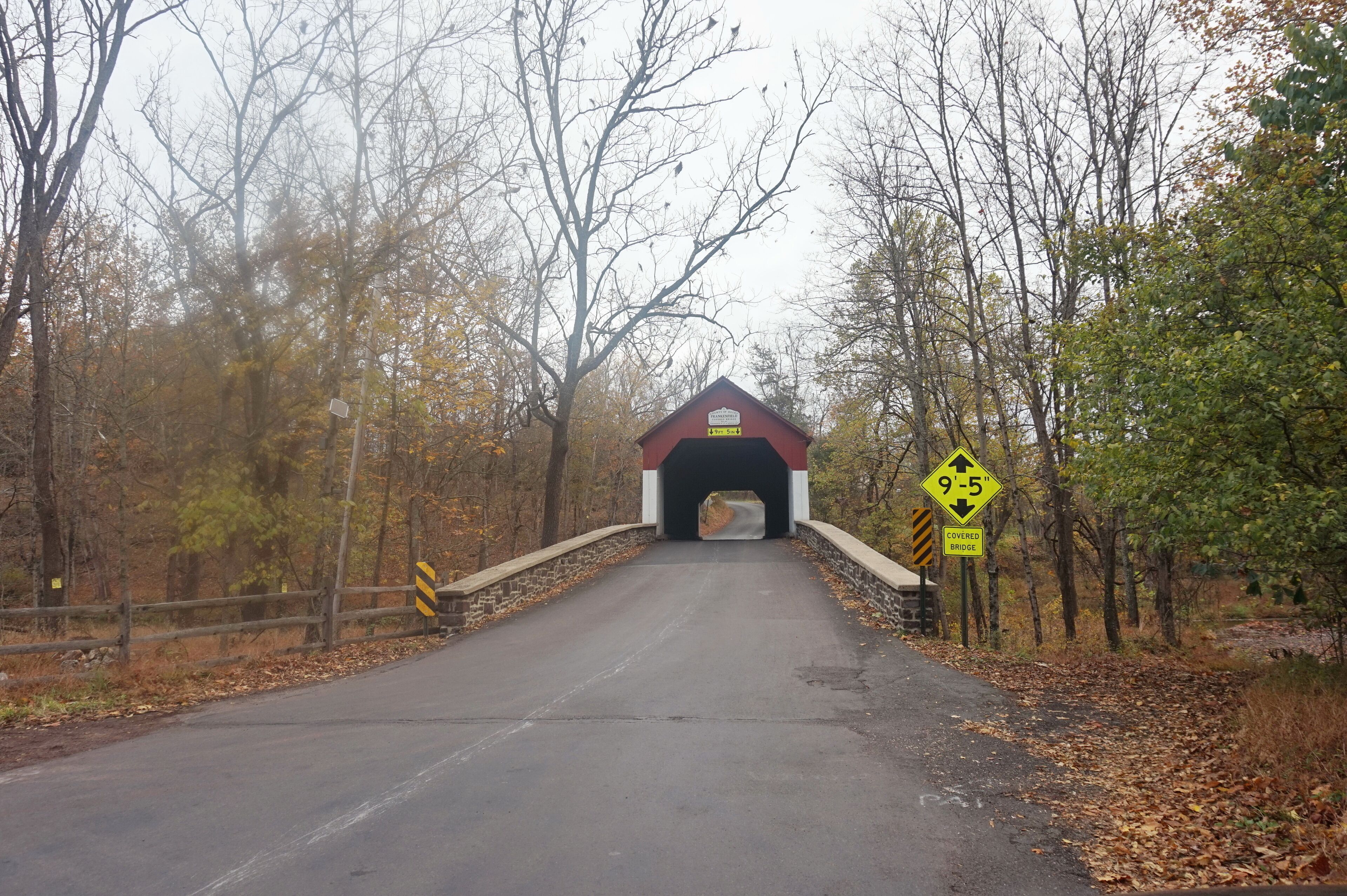 A covered bridge with a height restriction sign of 9-5 feet.