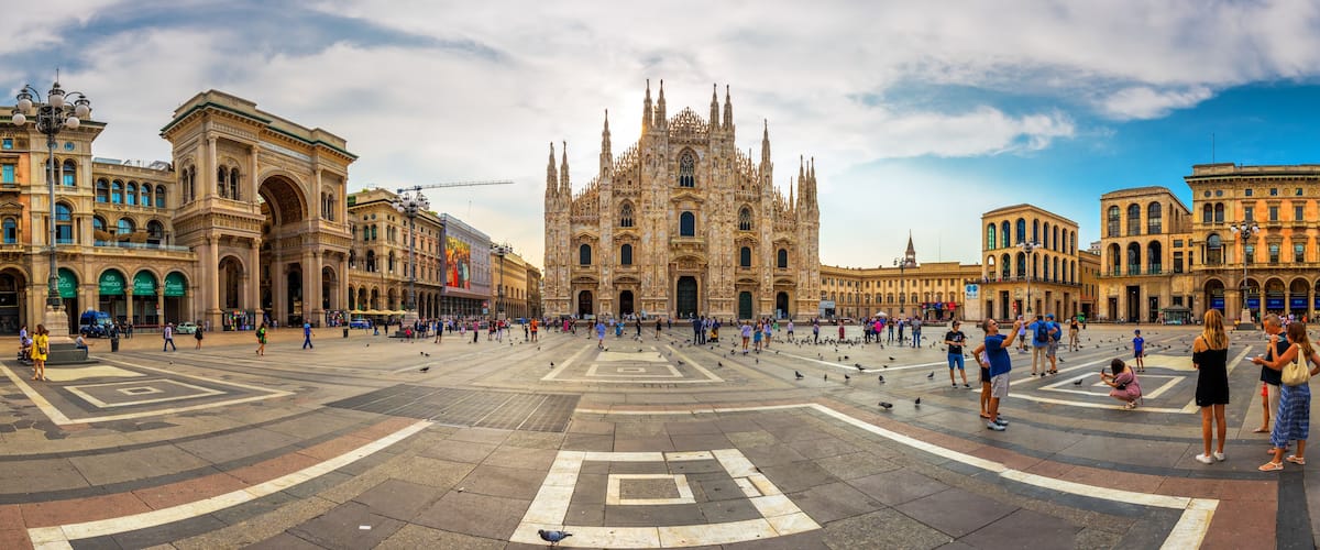 A large open square with a historic cathedral in the center, surrounded by classical architecture.