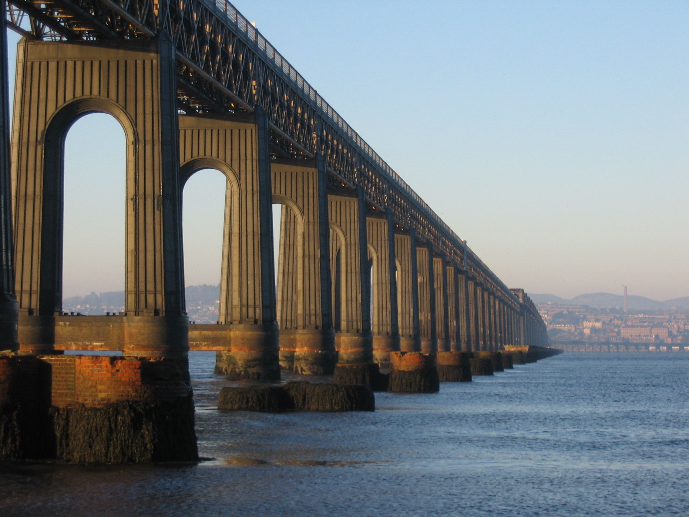 A large steel bridge with multiple arches spanning a body of water.