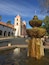A historic church with a bell tower and a fountain in the foreground.