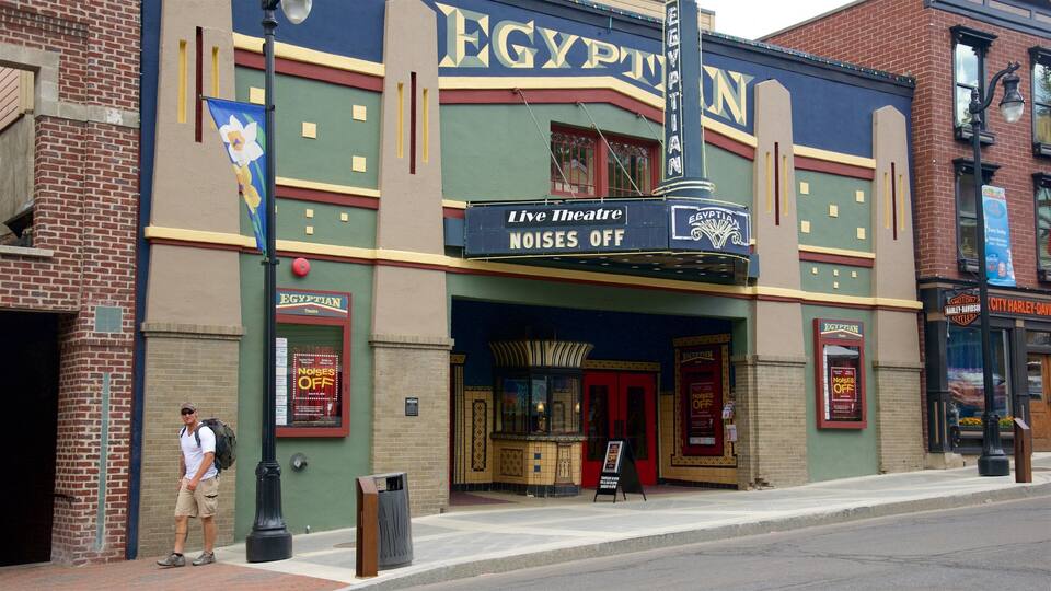 A theater with Egyptian-themed architecture and a sign indicating 'Live Theatre NOISES OFF'.