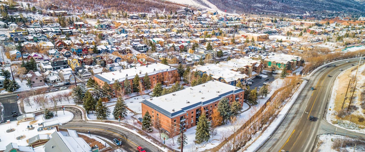 A snow-covered town with a mountain backdrop and a winding road.