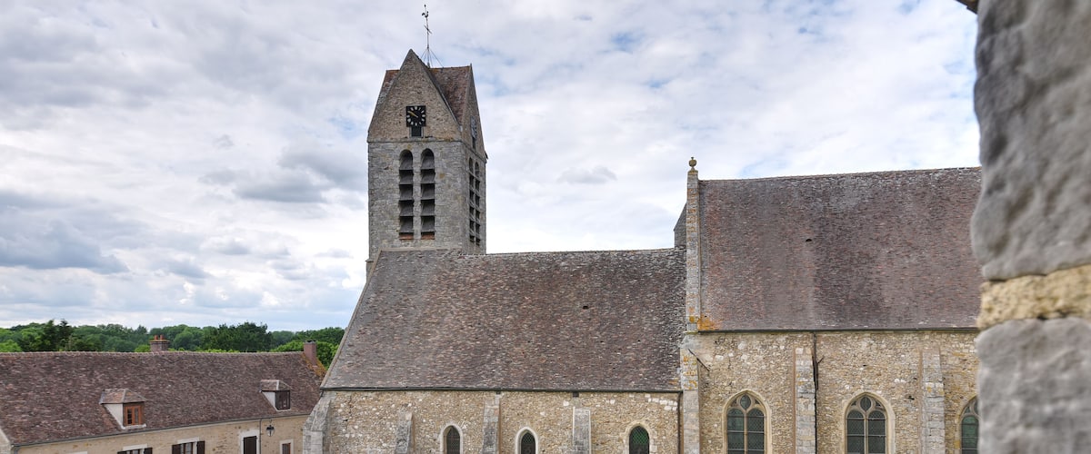 A historic stone church with a bell tower and arched windows.