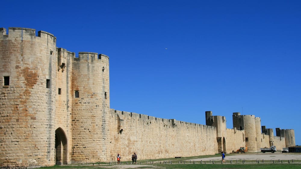 Un château historique en pierre, doté de nombreuses tours et d’une grande entrée en arc de cercle.