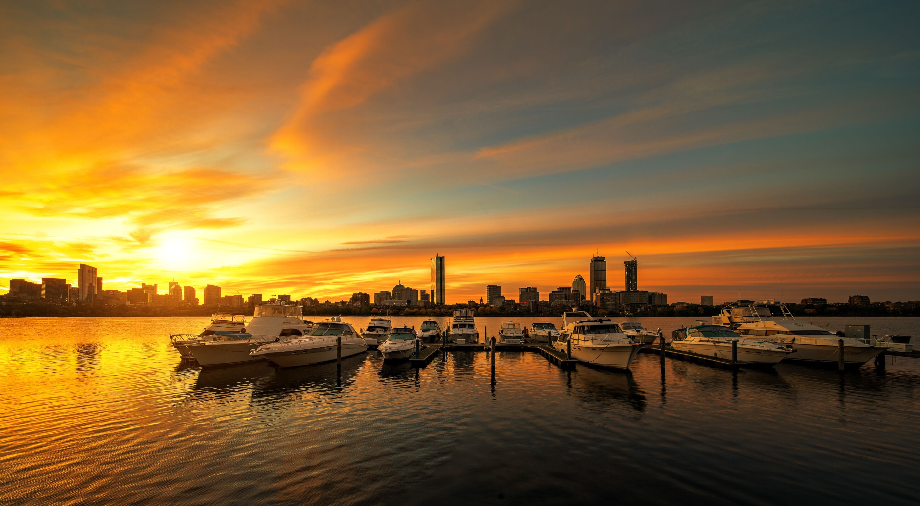 Sunrise over Boston city with boat and harbor