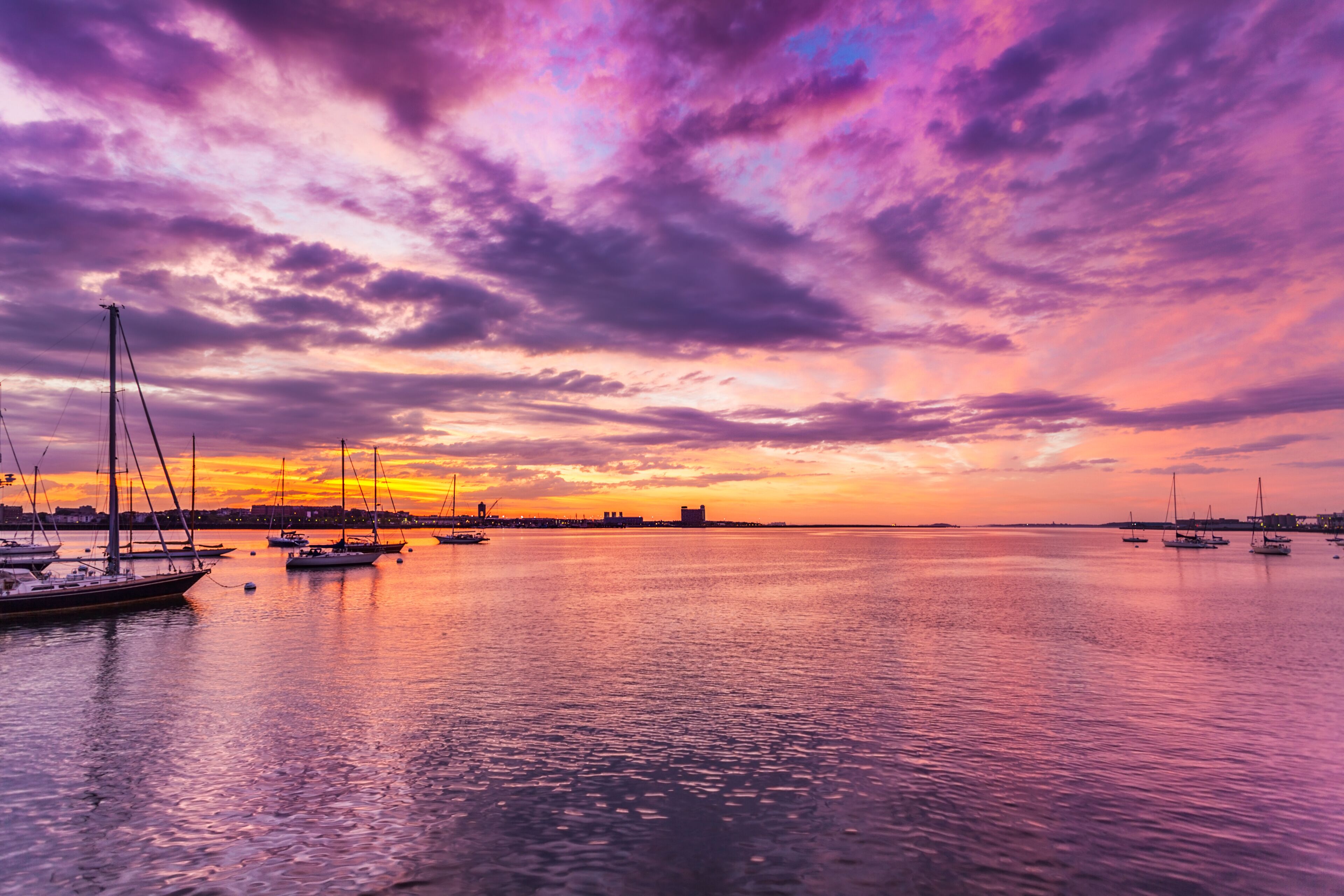 Clouds and vivid sunrise colors over Boston Harbor - normally busy harbor and Logan Airport are quiet in the early pre-sunrise hours