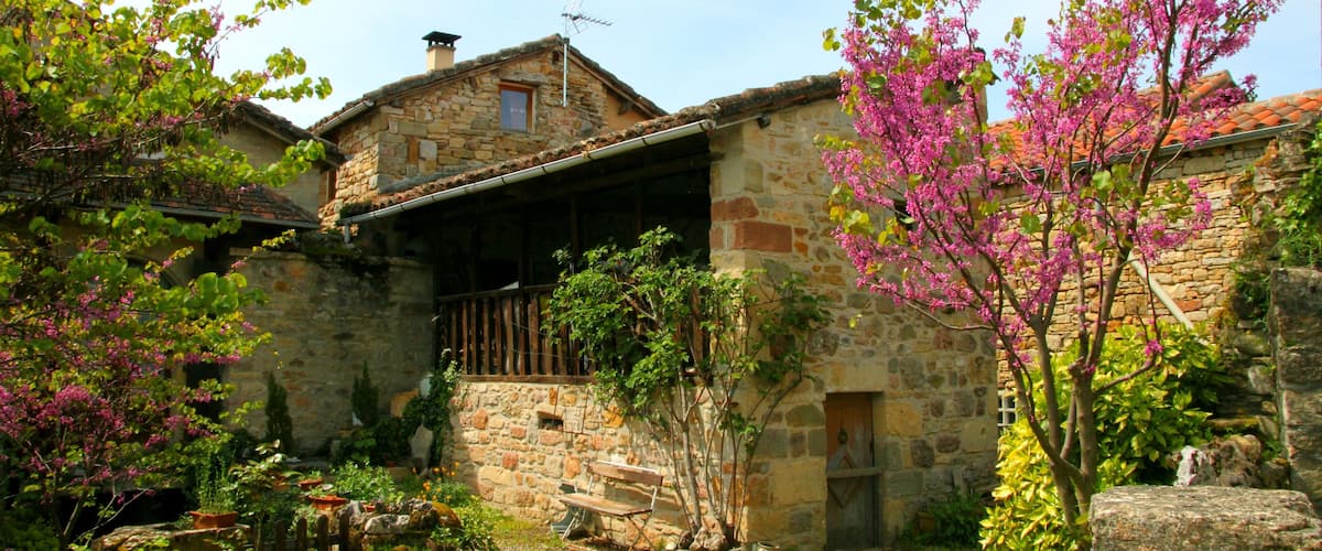 A stone building with a wooden door and a bench in front.