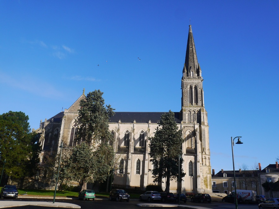 A historic church with a tall spire and large arched windows.