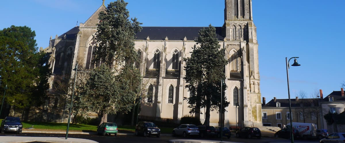 A historic church with a tall spire and large arched windows.