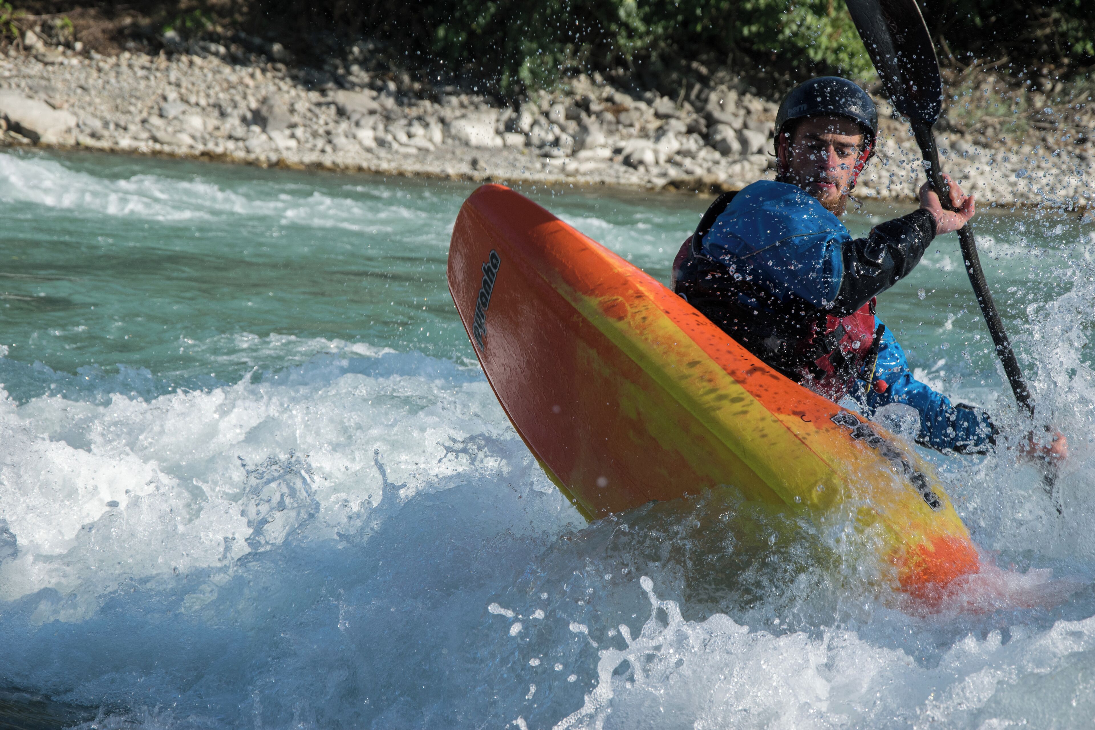 Kayaker playboating at the wave called la Clapière, at Embrun on the Durance river (France).