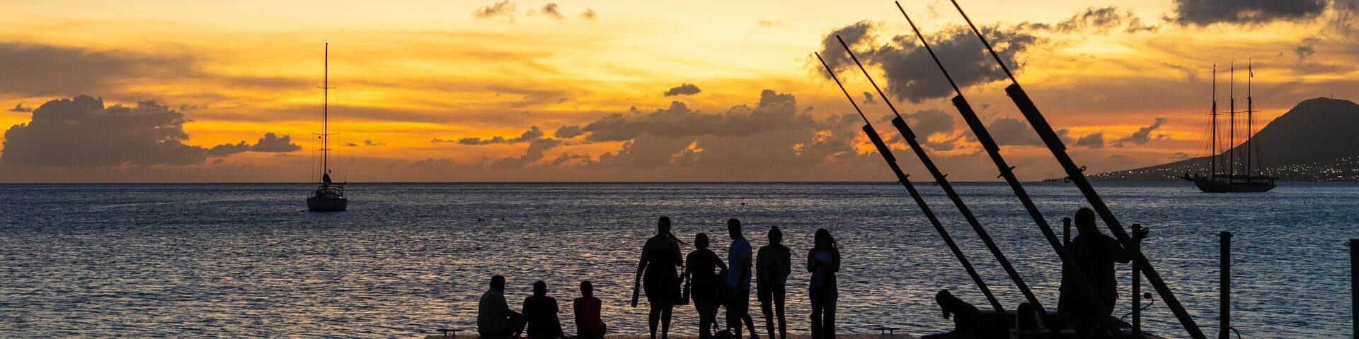 St. Kitts which includes general coastal views and a sunset as well as a small group of people