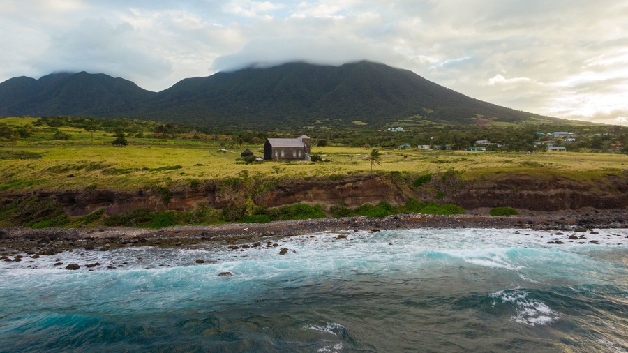 St. Kitts which includes rocky coastline, general coastal views and a sunset