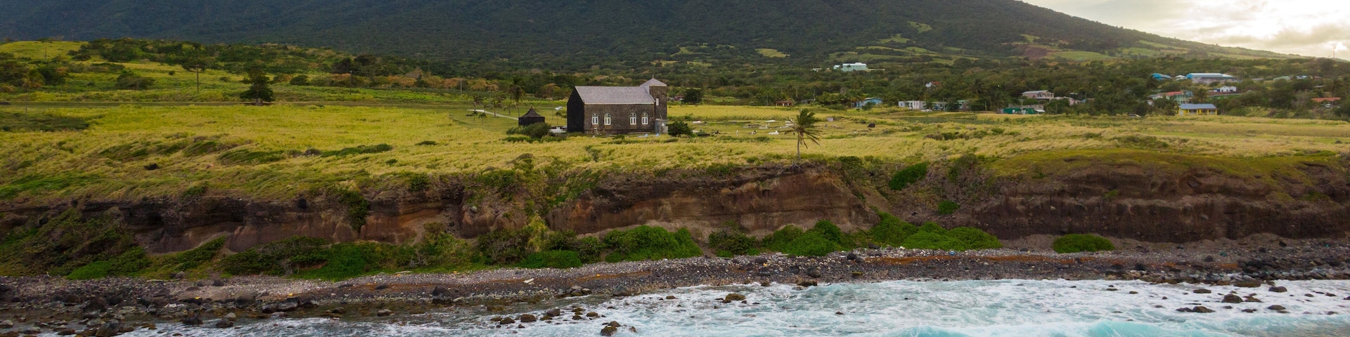 St. Kitts which includes rocky coastline, general coastal views and a sunset