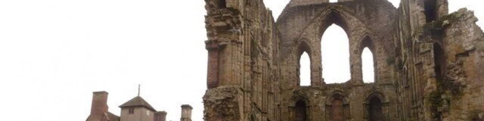 A historic stone building with Gothic architecture, including pointed arches and a large central tower.