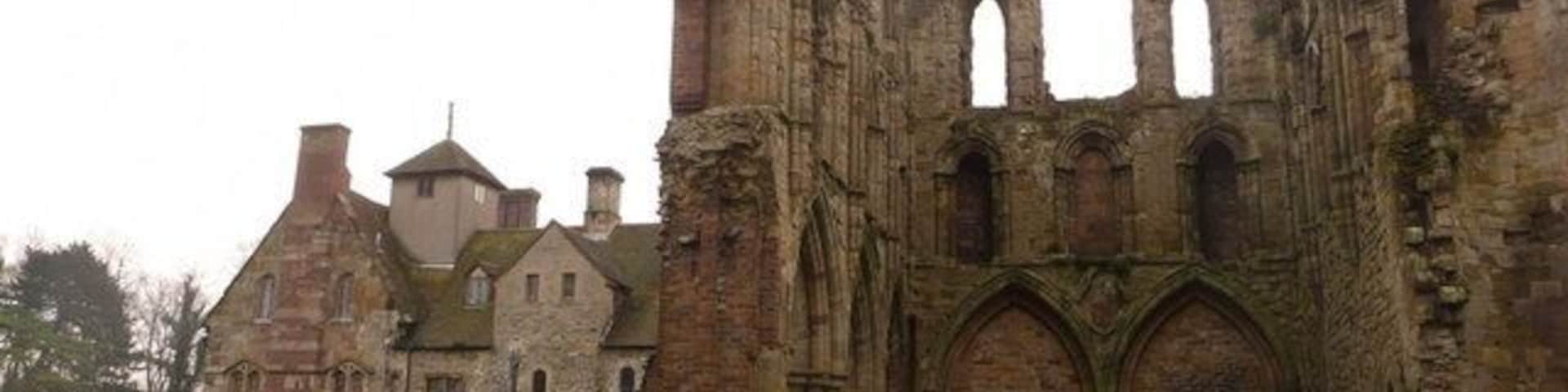 Un edificio histórico de piedra con arquitectura gótica, que incluye arcos apuntados y una gran torre central.