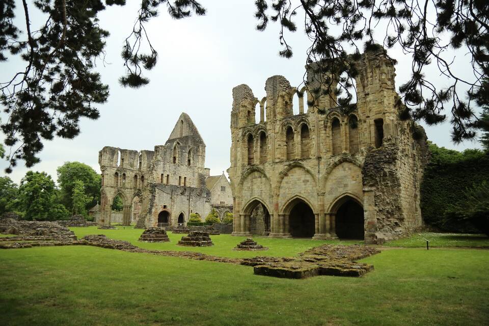 An ancient stone castle with ruins and grassy fields.