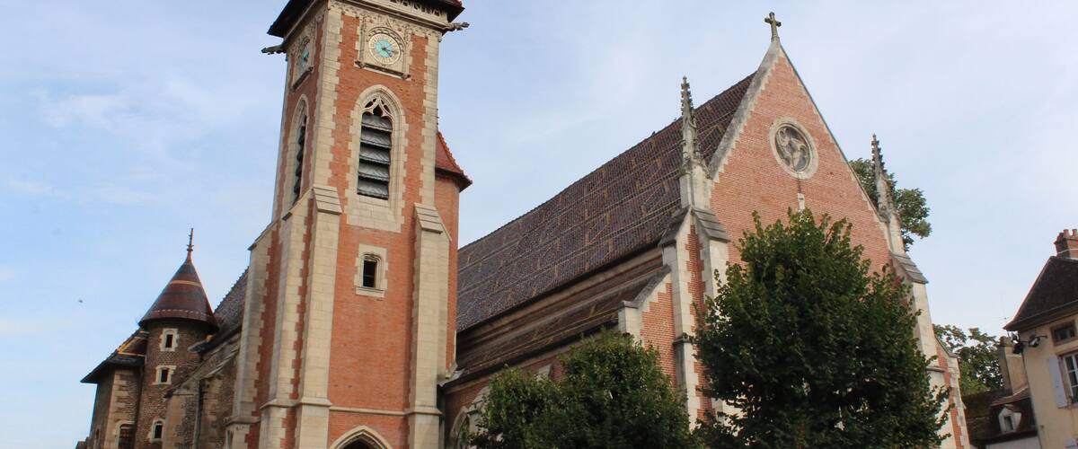 A historic church with a tall spire and a clock tower.