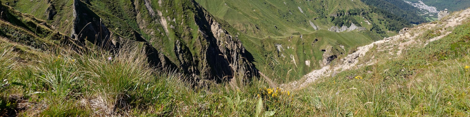 A mountainous landscape with green slopes and rocky outcrops.