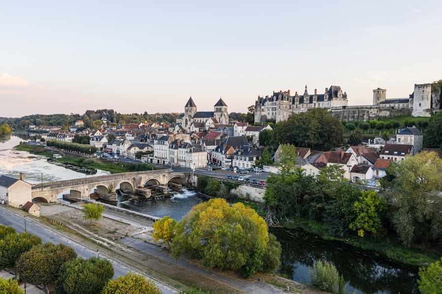 A historic town with a river, a bridge, and a castle-like structure.