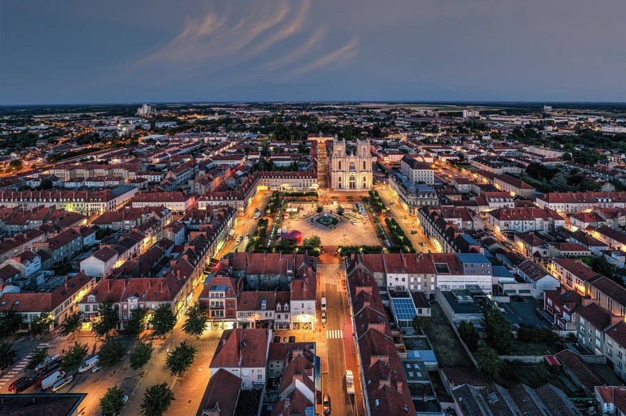 France, Marne, Vitry-le-Francois, Aerial view of illuminated city at dusk with clear line of horizon in background