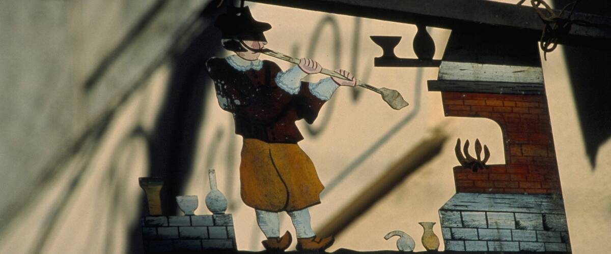 A stained glass window depicting a man playing a flute.