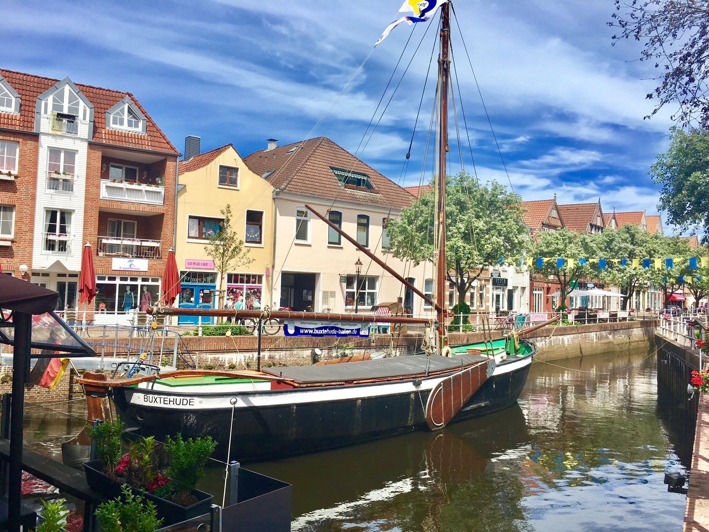 A canal with boats, a traditional building, and a flag.