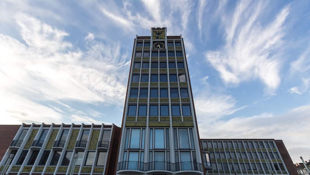 A modern building with a clock tower and the name "Rathaus" on the facade.