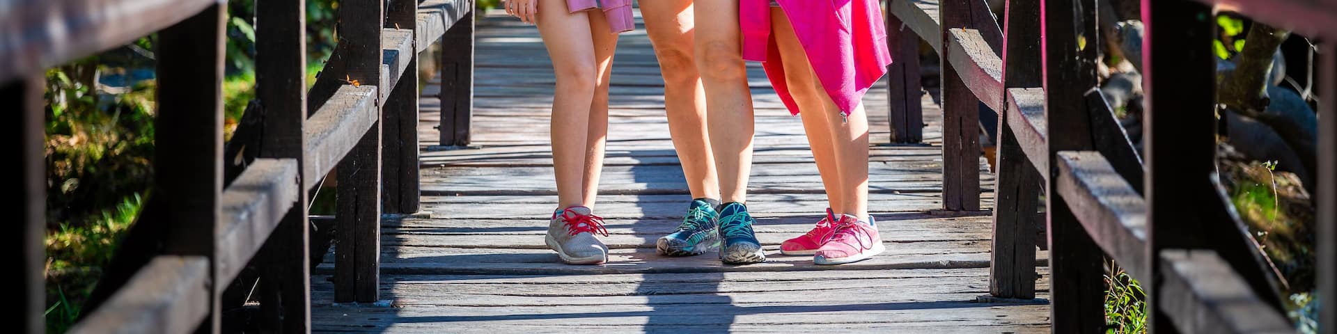 Family hiking on wooden bridges of Krka waterfalls. Mother and daughters walking the wooden bridge pathway on Krka river and waterfalls in Croatia.