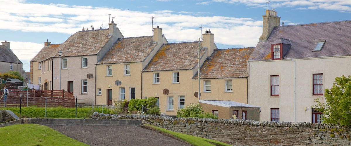 A row of traditional houses with sloped roofs and stone walls.