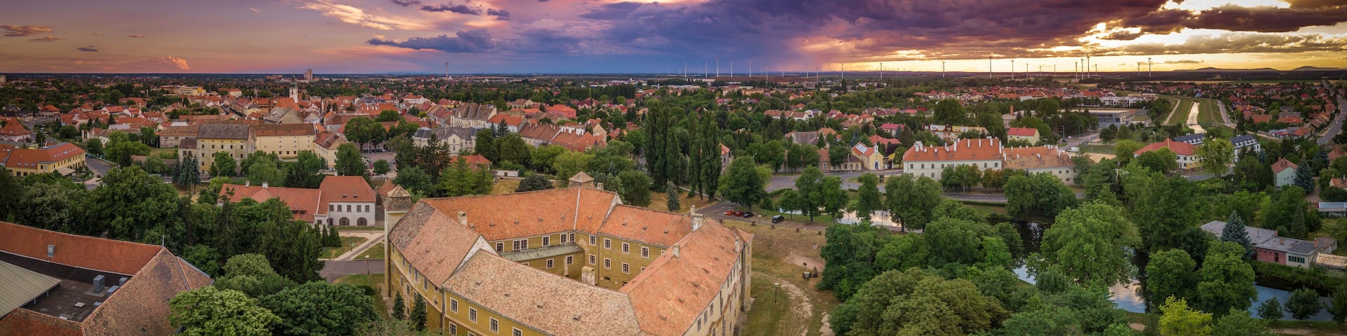 Stunning sunset with purple red blue orange and yellow colors over Mosonmagyarovar roman catholic church and castle in Hungary
