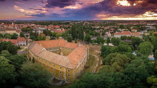 Stunning sunset with purple red blue orange and yellow colors over Mosonmagyarovar roman catholic church and castle in Hungary