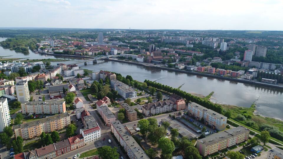An aerial view of a city with a river, bridges, and various buildings.